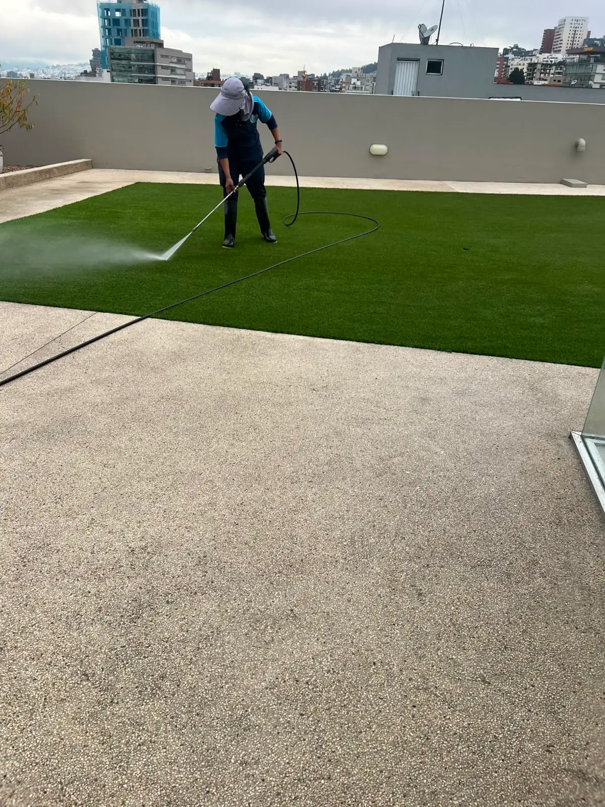 Equipo SUNSU lavando a presión el césped sintético de una terraza